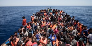 Migrants crowd the deck of their wooden boat off the coast of Libya